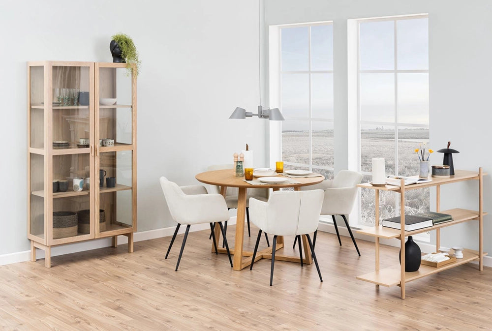Court Round Dining Table in Oak Finish with White Upholstered Chair and Glass Door Cabinet in Dining Setting